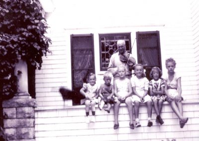 Henry Rogler with fiddle and kids