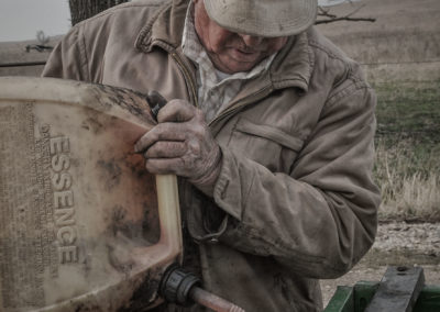 Rancher pouring mix of gasoline and kerosene in drip torch