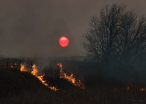 Landscape horizon with flames and setting sun photographed through thermals