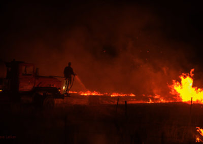 Rancher spraying water to control a burn